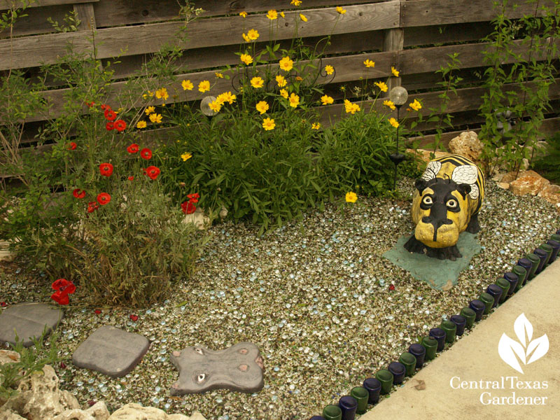 concrete "bee" hippo with coreopsis and poppy central texas gardener