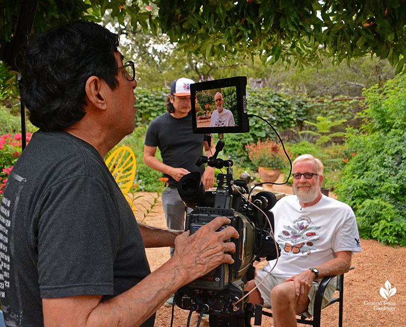 camera operator with monitor man sitting in chair in garden