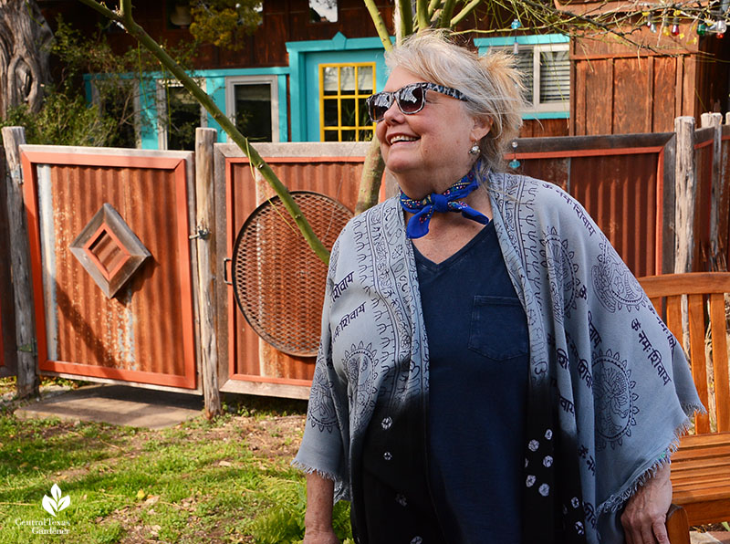 woman smiling in front of artistic metal gates