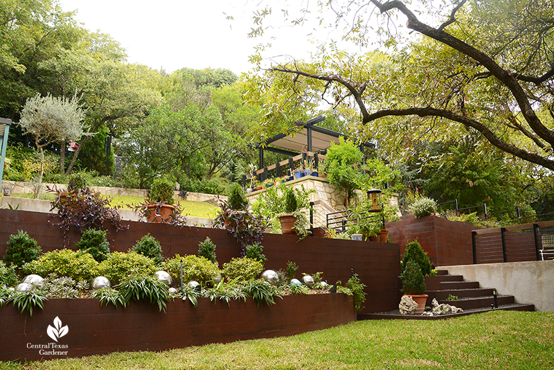 steel planters and retaining wall to upper outdoor living area sloped yard design Dujon Harper