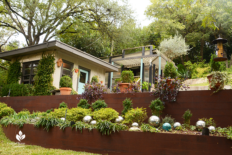 steel retaining wall sloped garden up to cute shed and greenhouse Dujon Harper garden