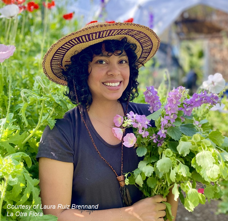 smiling woman in garden hat holding bouquet of flowers