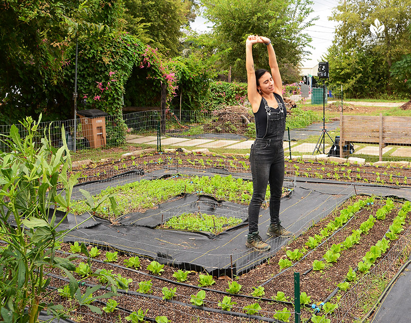 woman stretching in vegetable garden