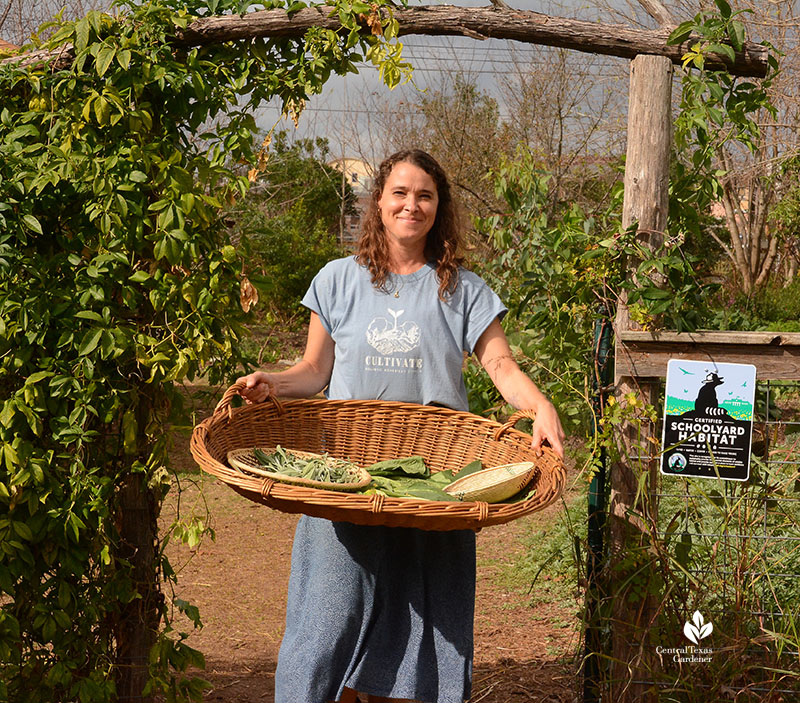 woman holding basket of cut herbs