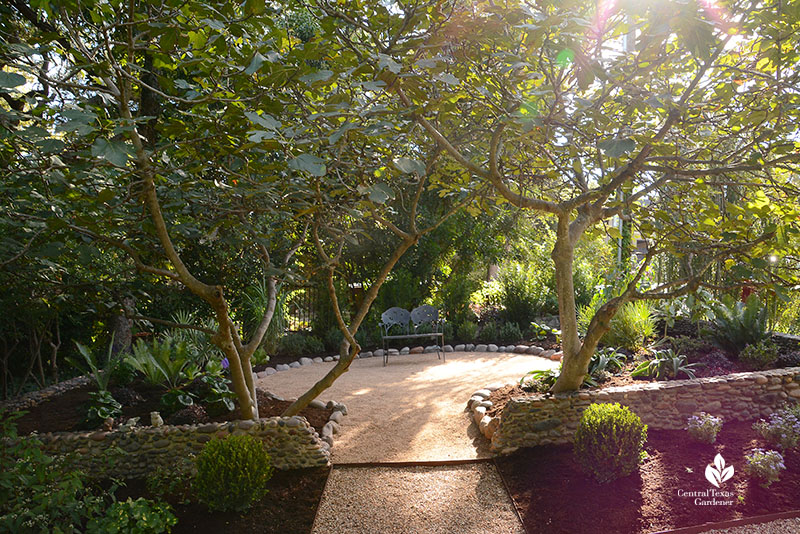 gravel patio framed by trees and shrubs