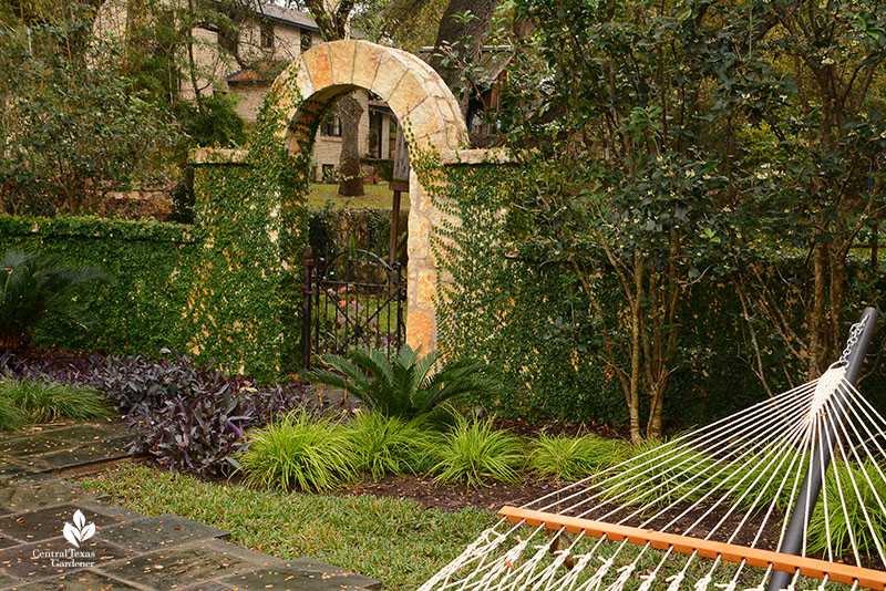 stone arch bordered with plants