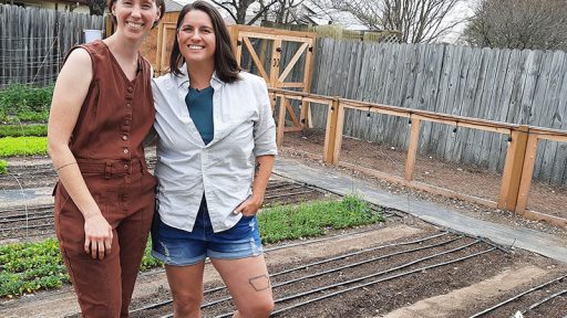 two women in yard of vegetable rows