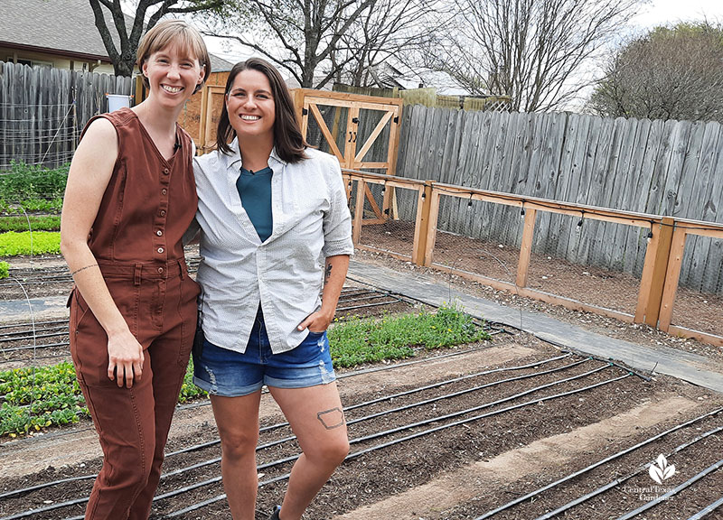 two women in yard of vegetable rows