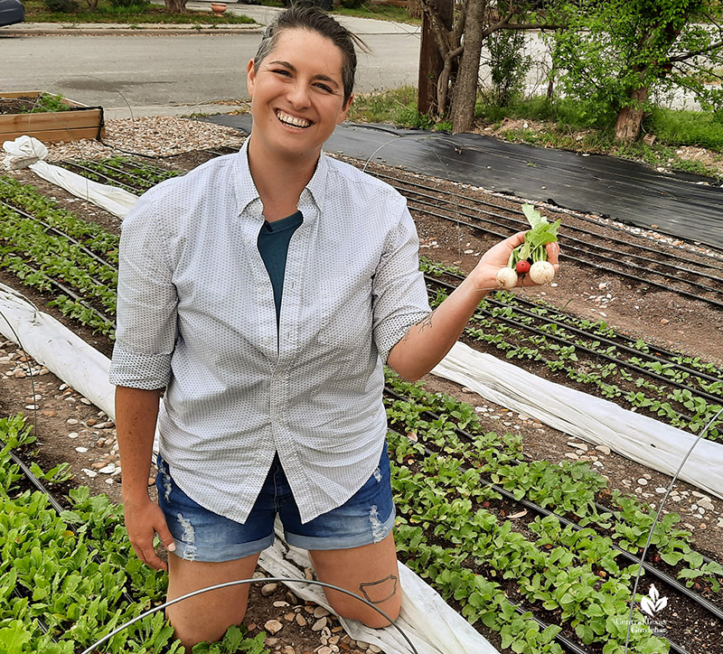 woman holding turnips and radishes