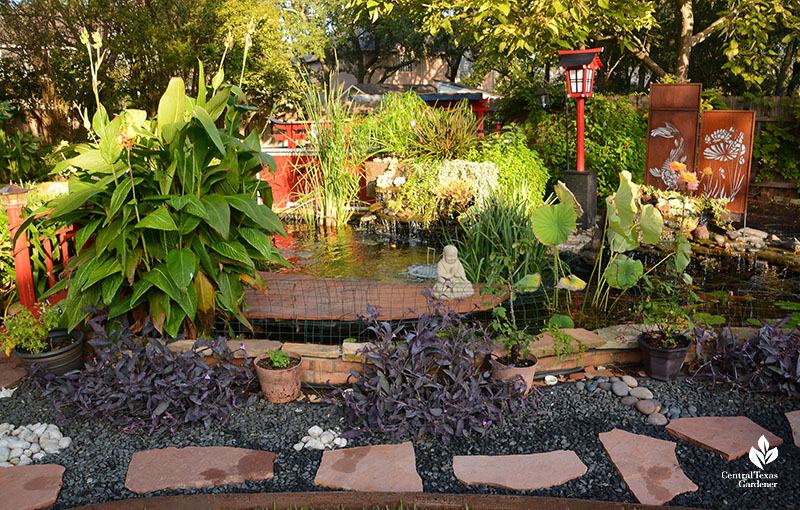 stone and gravel path red lantern and metal panels boardwalk with Buddha statue pond and waterfalls