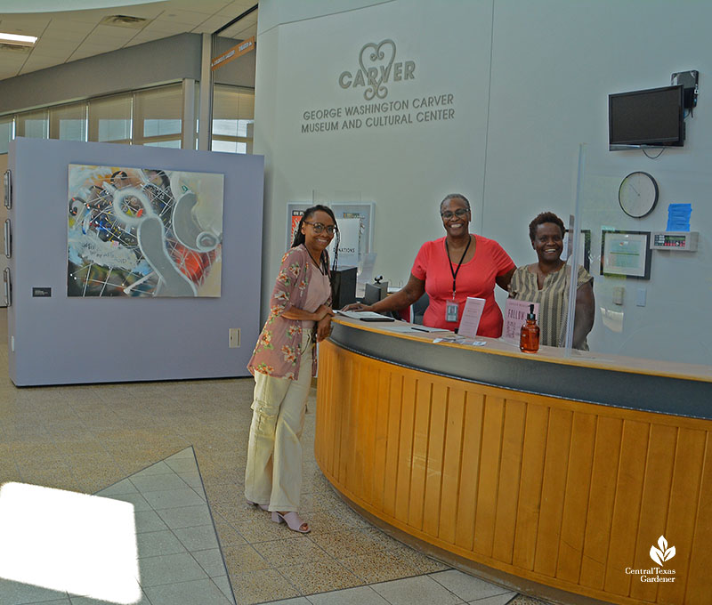 three women at reception area in art gallery