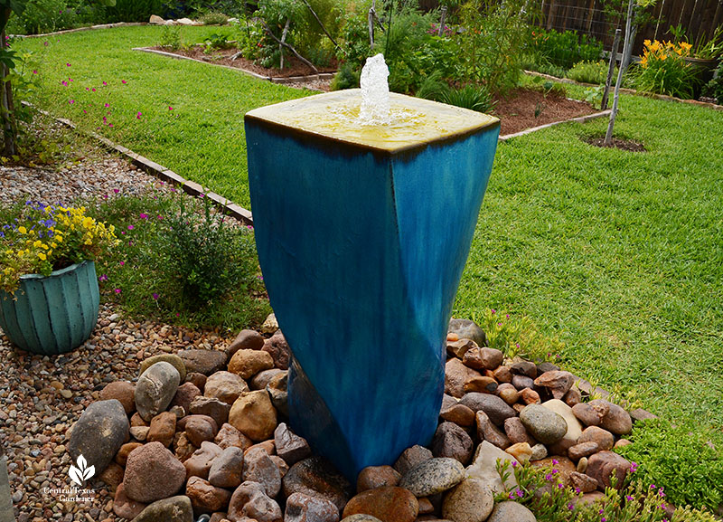 blue disappearing fountain on bed of rocks