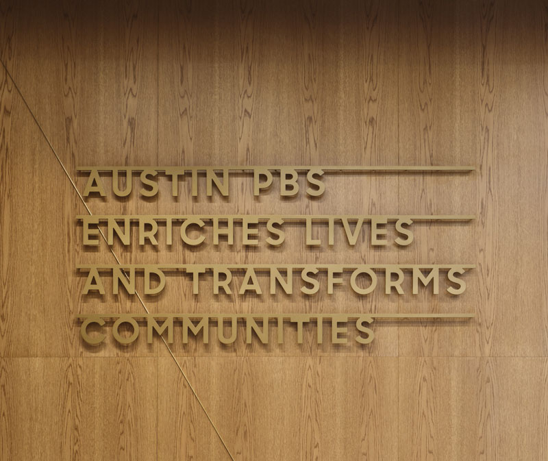 wall or door panel with raised characters to read Austin PBS Enriches Lives and Transforms Communities 
