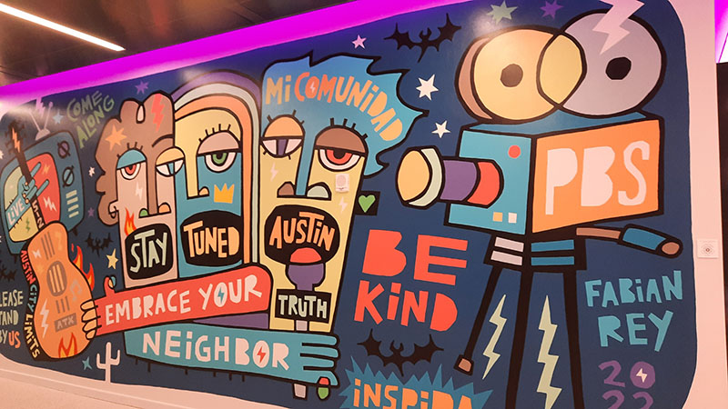 colorful mural with words Stay Tuned Austin Embrace Your Neighbor Be Kind PBS Micomunidad come along Fabian Rey 