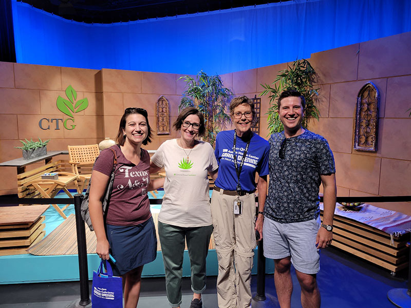 three smiling woman and man visiting CTG studio set 