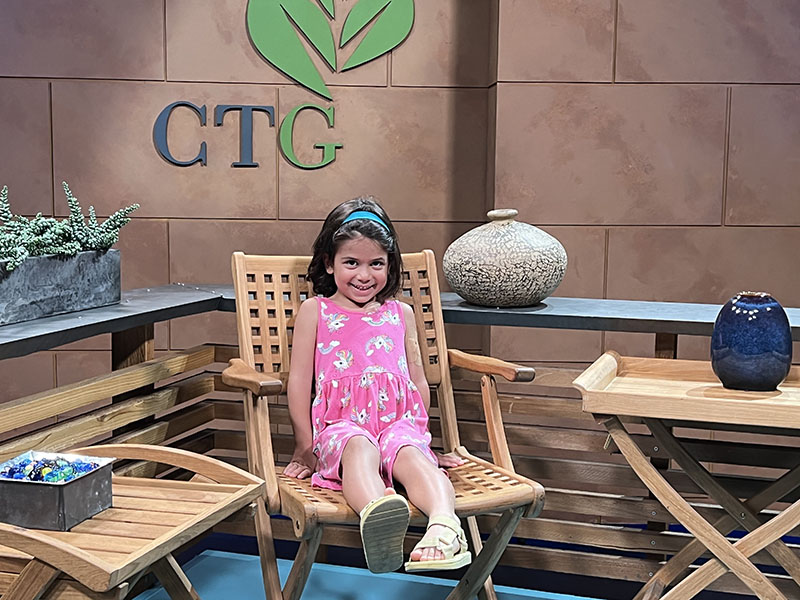 smiling child sitting in chair on CTG set