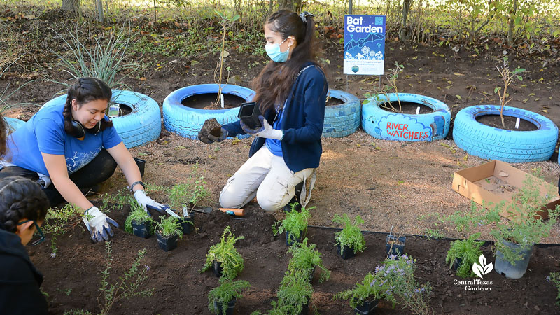 two teenage girls planting garden 