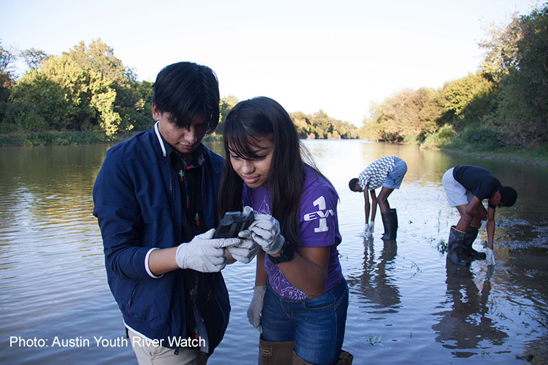 students checking water quality in a river