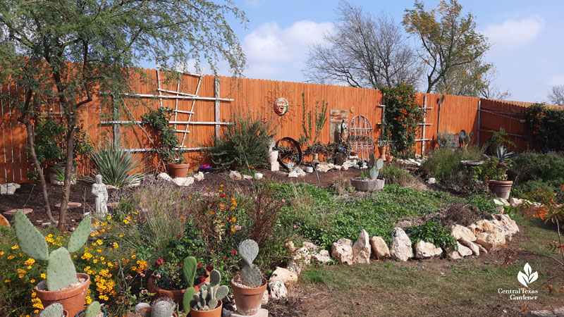 backyard sloping berm with plants bordered with limestone 