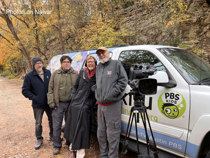 three men and woman with video gear near PBS vehicle