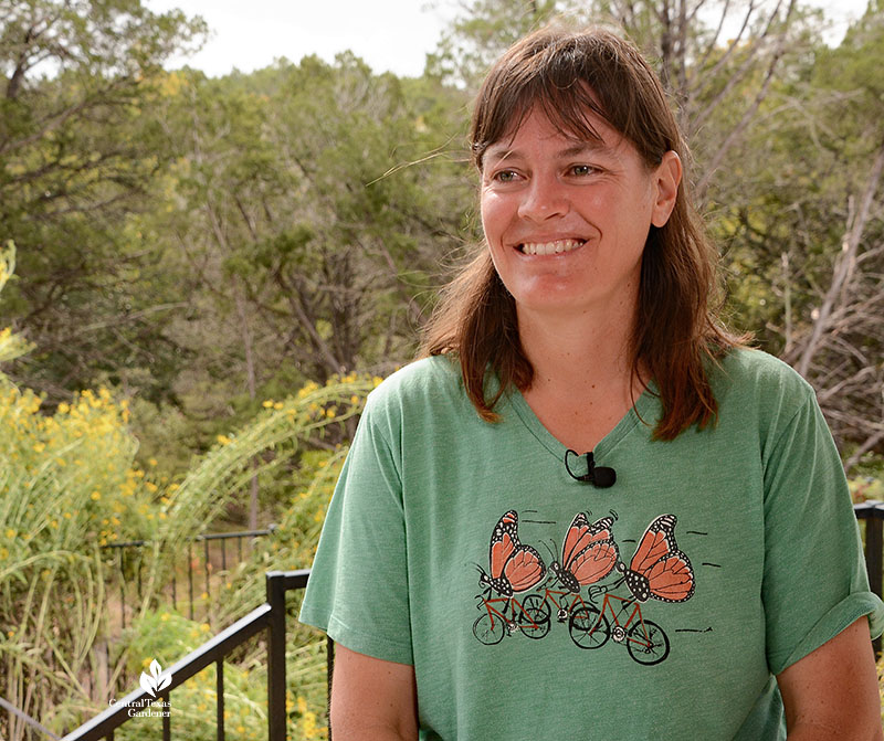 young woman smiling with plants in background