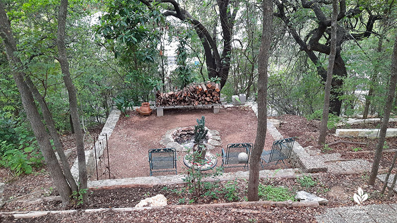 fire pit surrounded by limestone blocks with view beyond trees