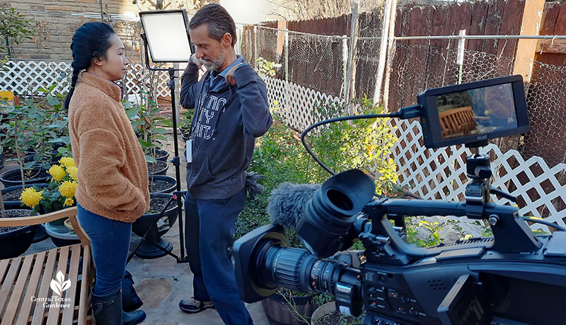 woman and man in backyard with TV lights and camera