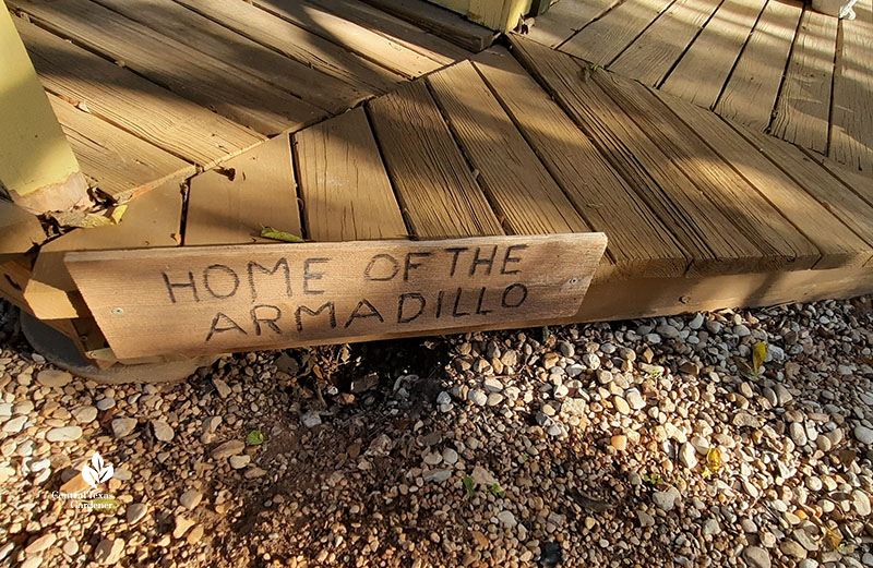 Home of the Armadillo sign over hole dug under a deck 