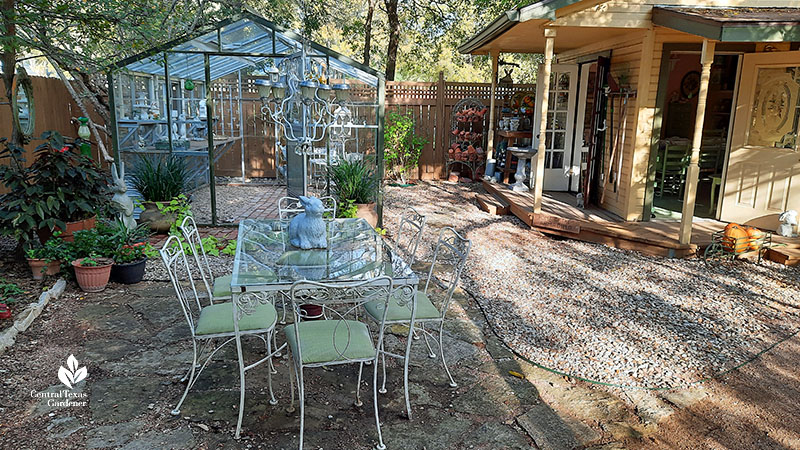 glass dining table with bunny sculpture on top and beyond a glass greenhouse