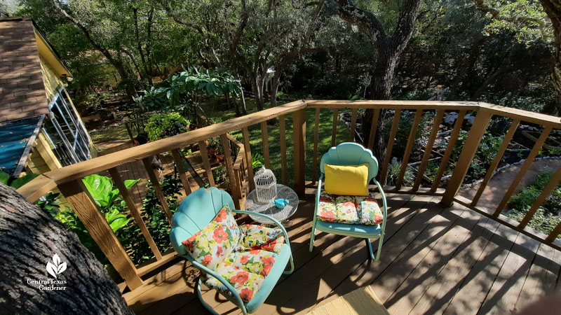 colorful patio chairs on treehouse patio with view to gardens below