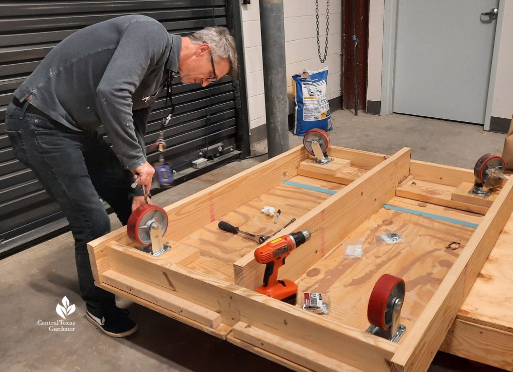 man drilling casters into platform 