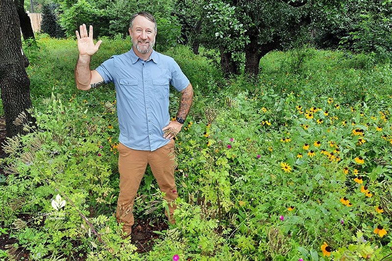 man waving in wildflower field 