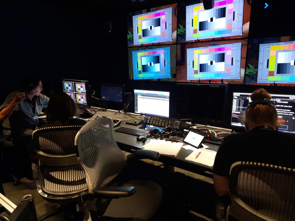 control room with monitors and two people 