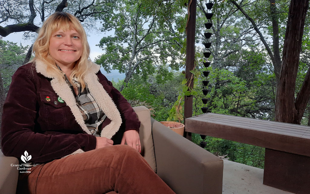 smiling woman in chair with fall garden beyond