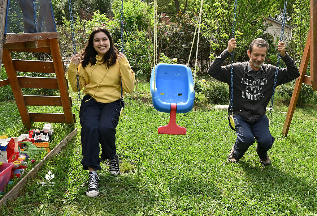 young woman and man on backyard swing set 