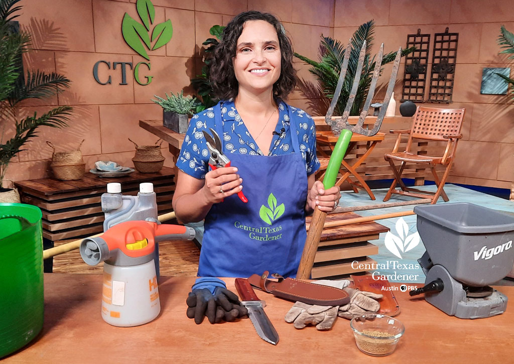 smiling woman holding garden tools in studio