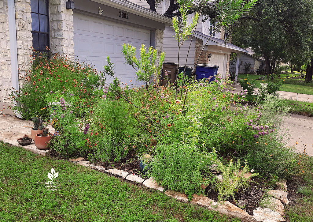 flower-filled garden bed next to driveway to garage