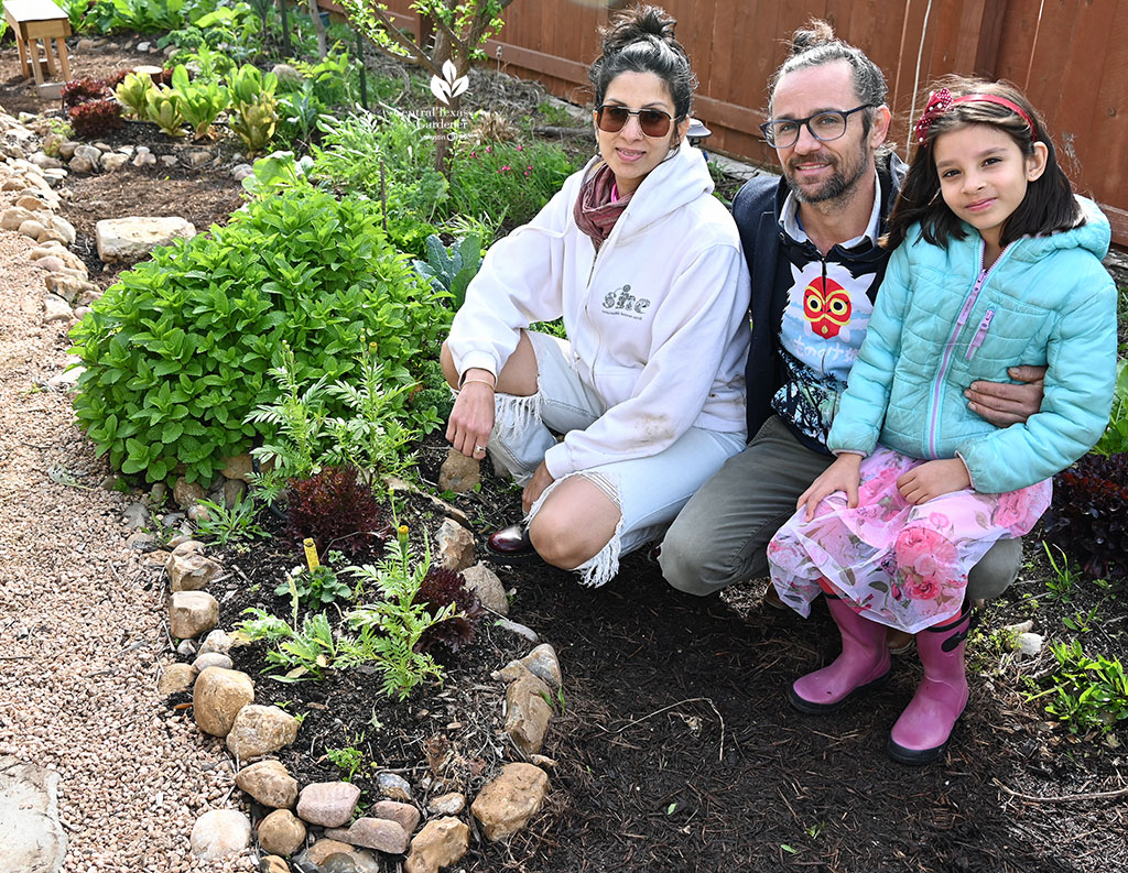 woman, man, and child in a garden