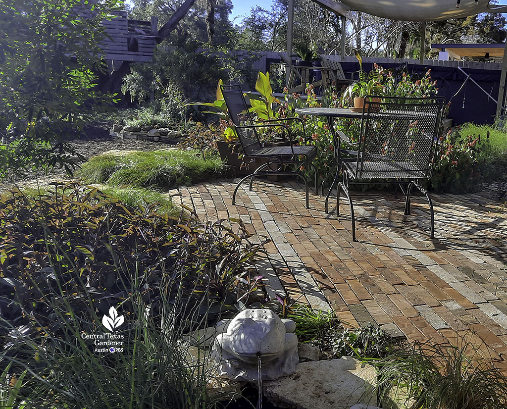 brick patio, metal mesh table, colorful plants, small in-ground watering hole for wildlife 