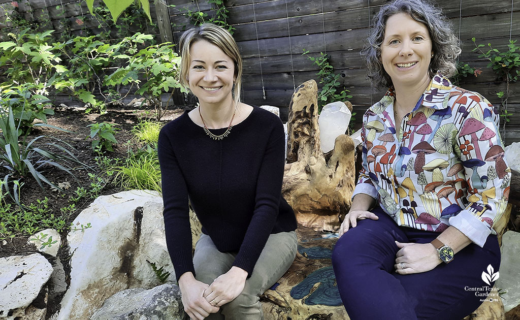 two women seated on wooden bench in garden