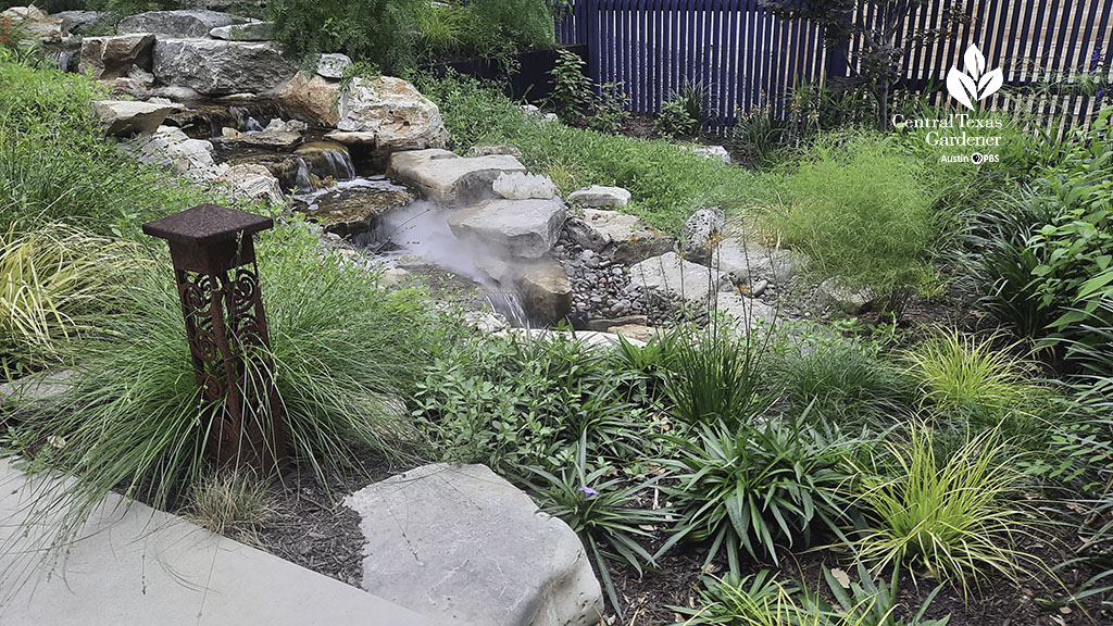 narrow front yard stream and waterfall (with fog machine) bordered by plants