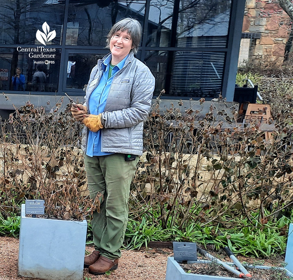 smiling woman in front of stone wall and winter brown plants