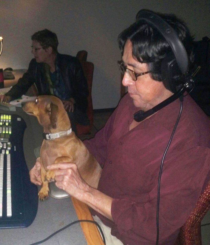 dog sitting in director Ed's lap in control room 