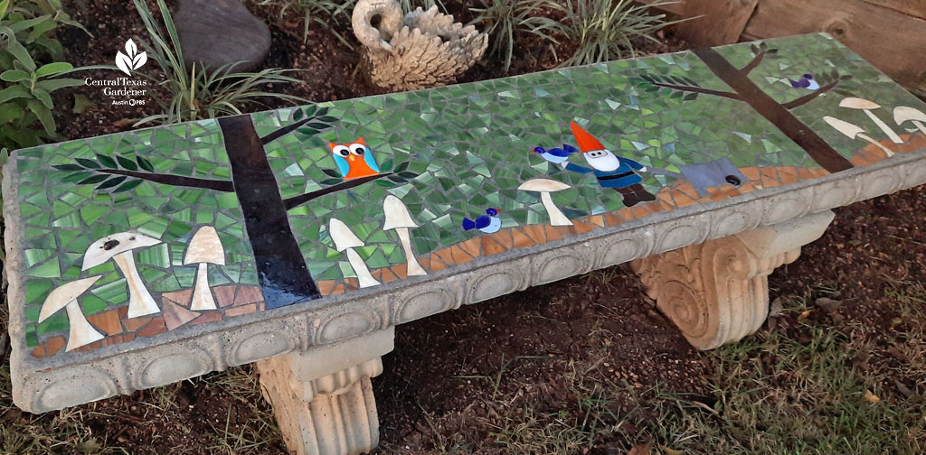 colorful mosaic on bench top featuring a gnome, owl , small bird, and mushrooms