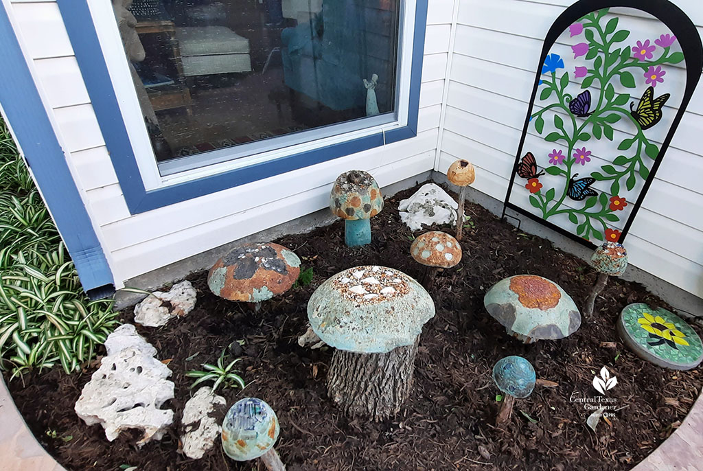 variety of concrete and painted mushrooms next to house window