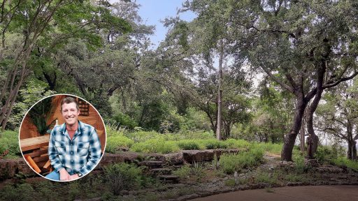 large trees and garden against low stone walls: smiling man in circle