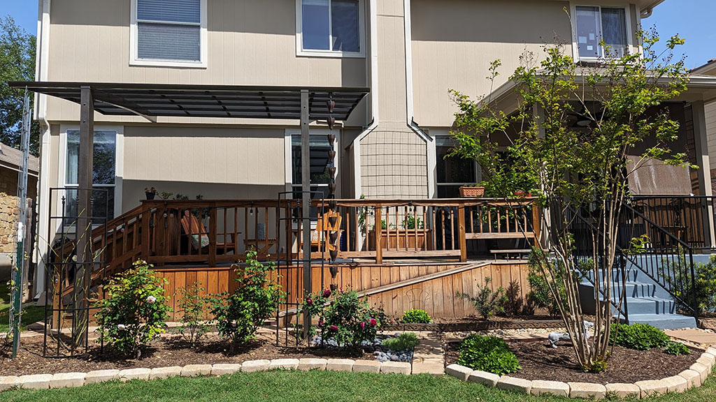 gardens in raised brick beds next to house deck 