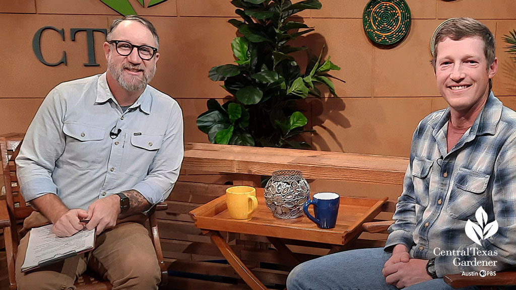 two smiling men on television set 