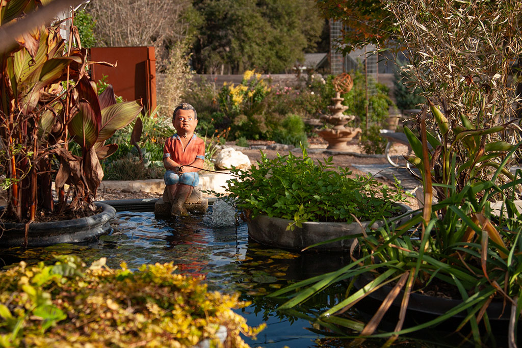 small pond with colorful plants and figurines 