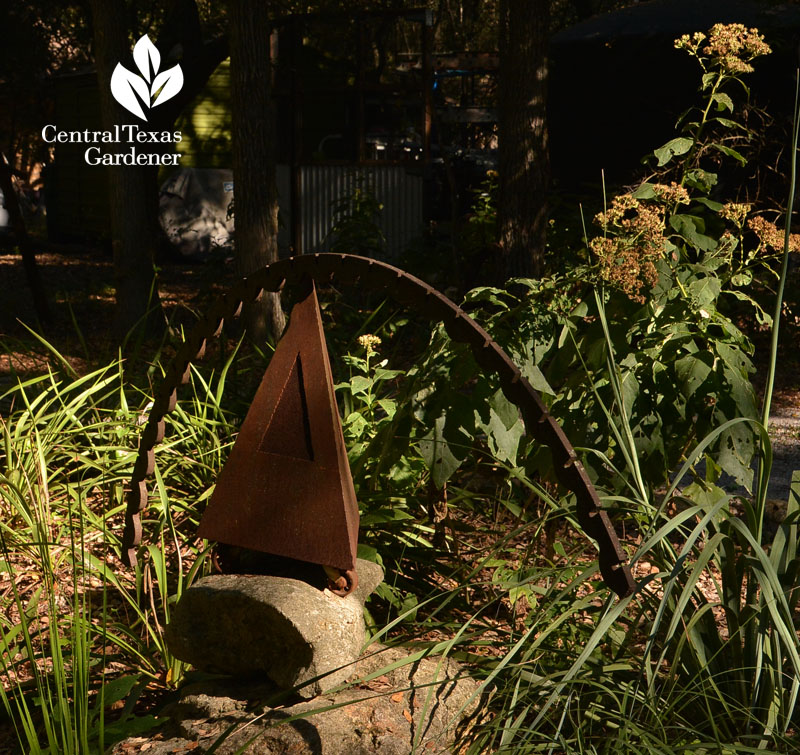 metal garden sculpture against frostweed seed head